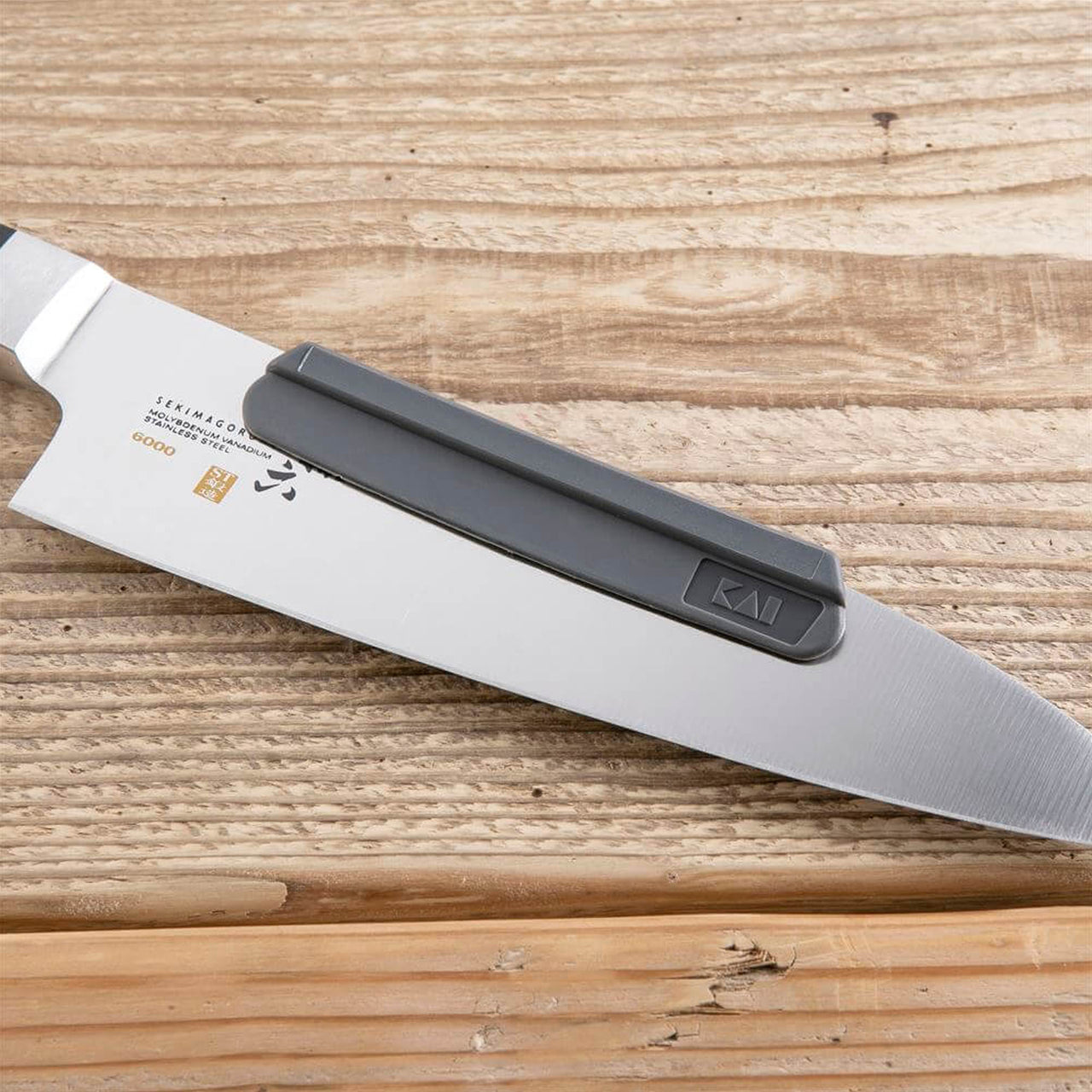 https://www.boroughkitchen.com/cdn/shop/products/kai-whetstone-sharpening-aid-on-knife-borough-kitchen_1280x.jpg?v=1674040712