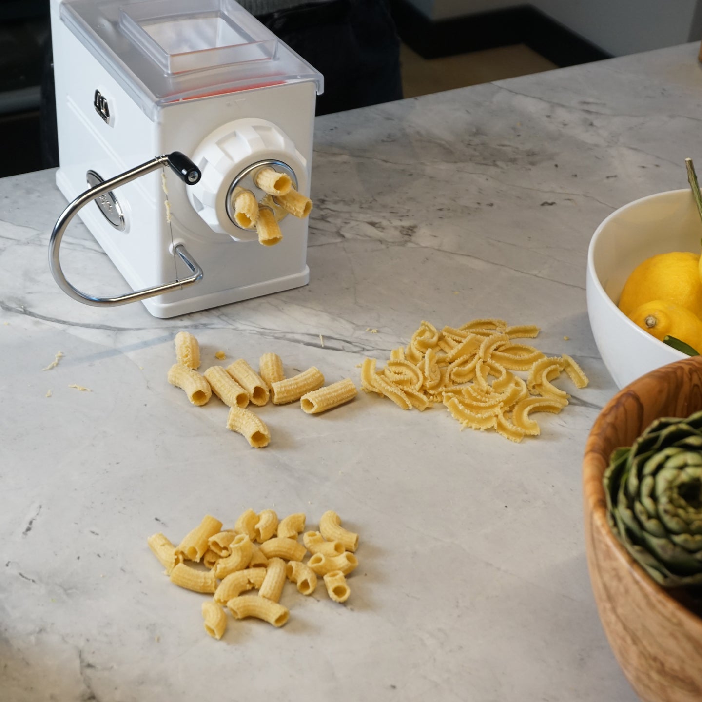 https://www.boroughkitchen.com/cdn/shop/products/marcato-regina-pasta-extruder-machine-lifestyle-with-shapes-borough-kitchen_2048x2048.jpg?v=1679501179