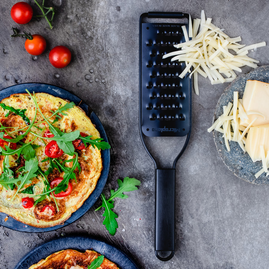 https://www.boroughkitchen.com/cdn/shop/products/microplane-black-sheep-extra-coarse-grater-lifestyle-pizza-borough-kitchen_900x900.jpg?v=1662381889